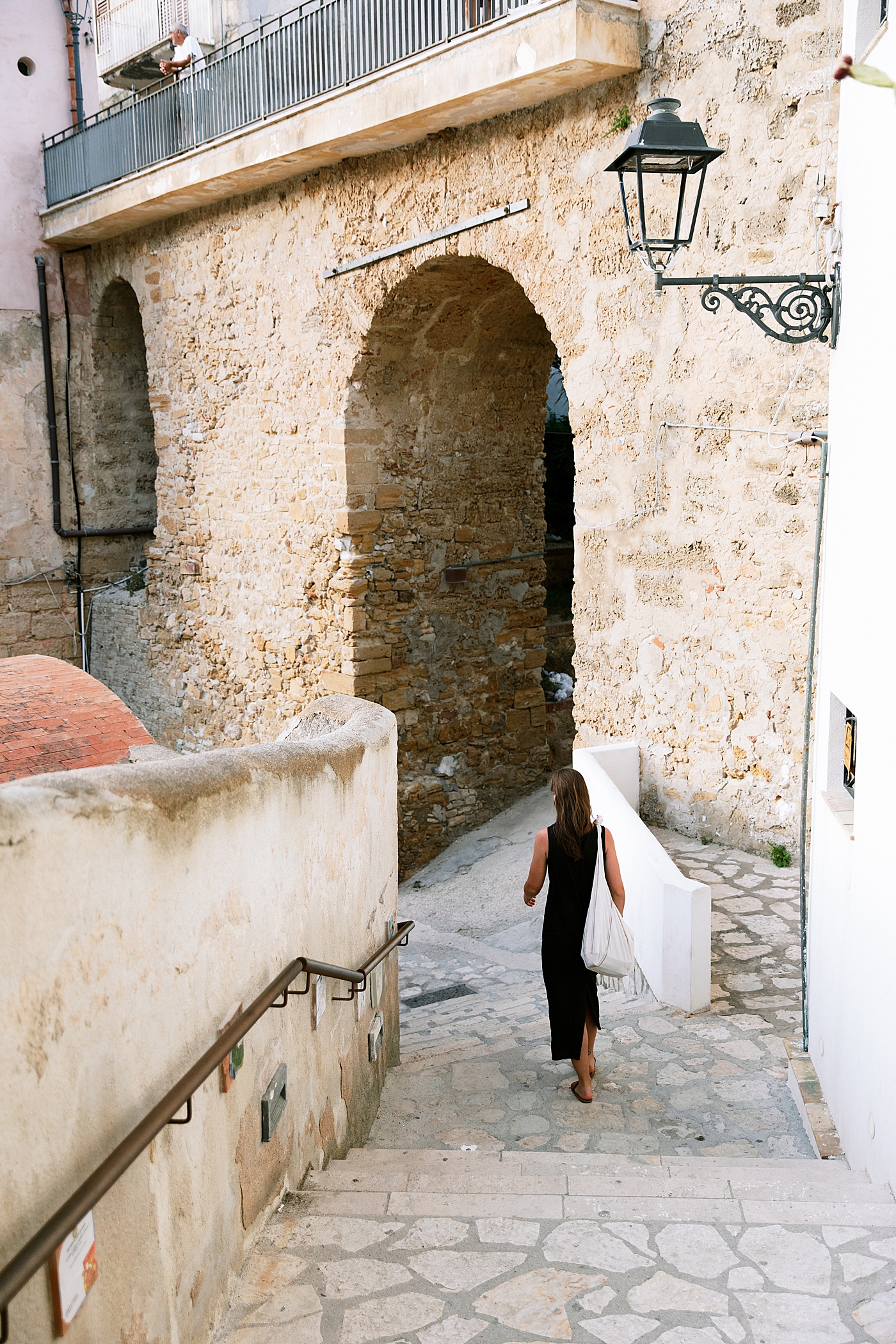 A woman with a tote bag walking through Castellammare del Golfo | Photo by Josie Derrick 