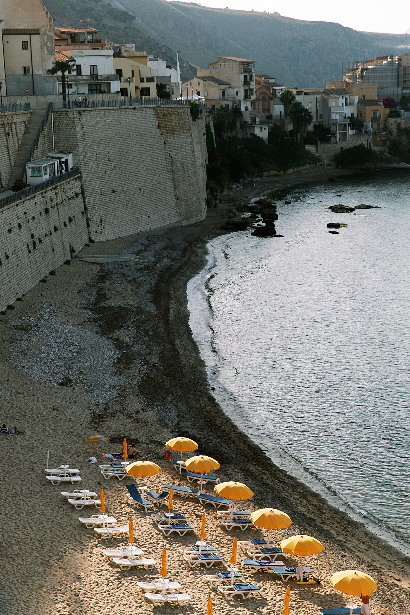 Yellow umbrellas on the beach of Cala Petròlo | Photo by Josie Derrick 