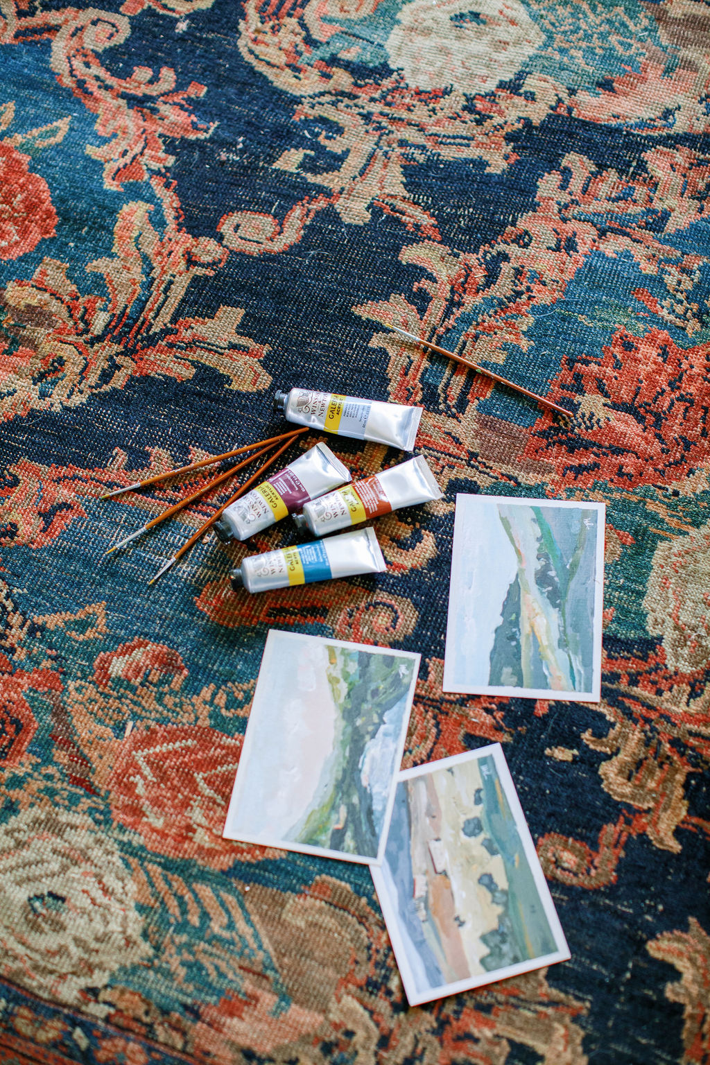 Artists paints and prints on a colorful Persian rug I Image by Josie Derrick